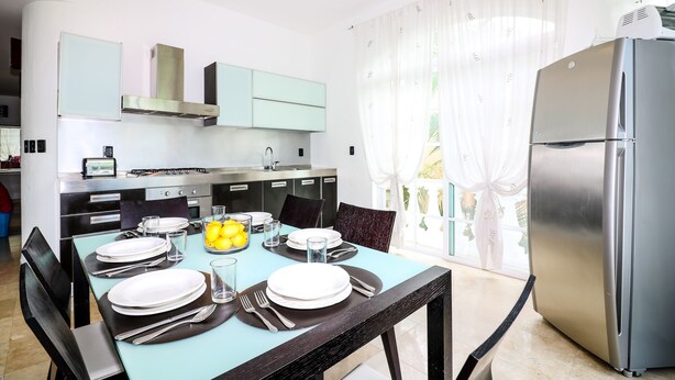 A modern kitchen with a dining area set for four. - Apartment Castello 1B (Playa del Carmen)
