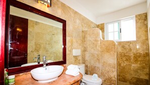 A bathroom with a marble sink, a toilet, and a shower. - Apartment Castello 1C (Playa del Carmen)