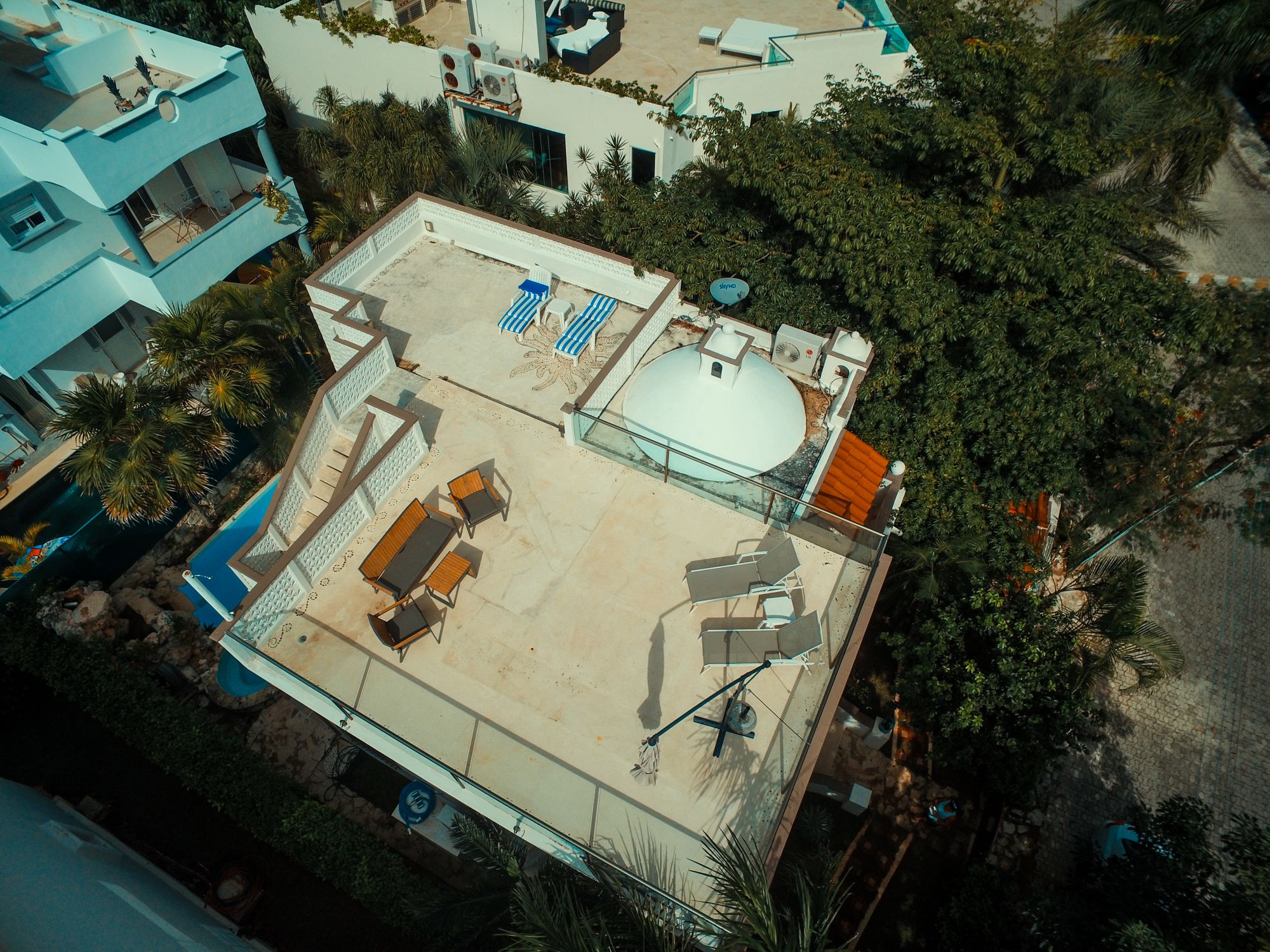 Eine Dachterrasse mit Pool, Liegestühlen und einer überdachten Sitzgelegenheit.