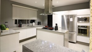 Uma cozinha moderna com bancadas de granito, eletrodomésticos de aço inoxidável e uma ilha central.