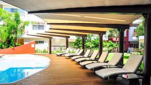 A poolside area with lounge chairs and a hot tub. - Apartment Sabbia B402 (Playa del Carmen)
