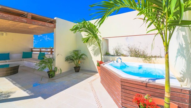 A rooftop terrace with a hot tub, seating area, and potted plants. - Apartment Sabbia B402 (Playa del Carmen)