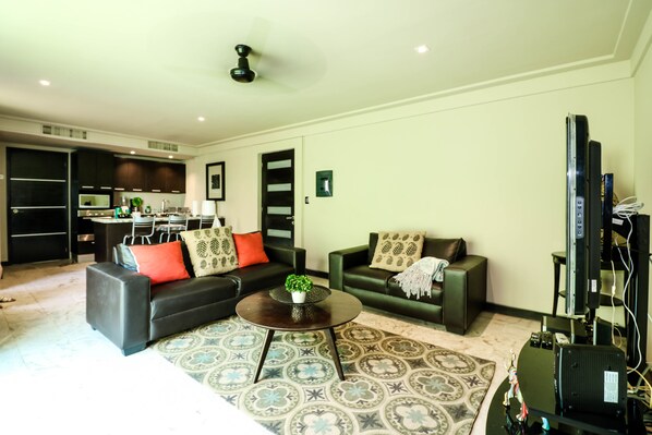 Una sala de estar moderna con un sofá, una mesa de centro y un mueble para la televisión.