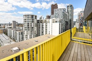 A high-rise building with a yellow railing, multiple balconies, and a cityscape in the background. - Millharbour Residences (London)