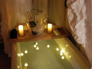A room with a wooden tray holding a bottle of champagne, glasses, and candles. - Denmark Stage Stop House (Denmark)