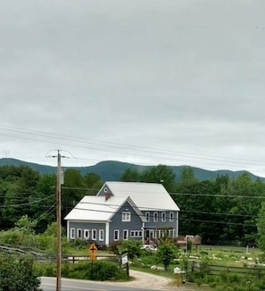 A two-story house with a gabled roof, surrounded by greenery and hills in the background. - Denmark Stage Stop House (Denmark)