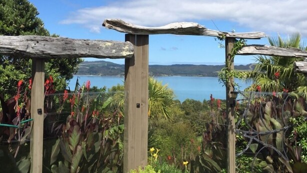 A wooden pergola structure with a view of a lake and mountains in the background. - MUDBRICK BARN MUDENZA VU (Opononi)
