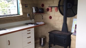 A kitchen with a stove, a window, and a sink. - MUDBRICK BARN MUDENZA VU (Opononi)