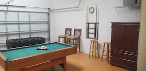 Enjoy a game of pool or foosball in this cozy recreational room with a pool table and foosball table.