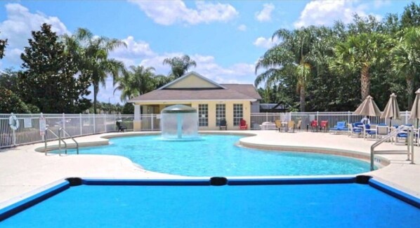 Relax by the pool surrounded by lounge chairs and umbrellas.