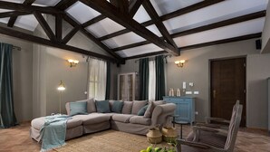 A cozy living room with a sectional sofa, a small table with fruit, and a blue cabinet. - Luxury villa with heated pool (Višnjan)