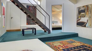 A staircase leading to a bedroom with a bed and a painting on the wall. - ARNOLDI~Rooftop (Venezia)