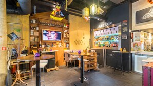 A cozy bar area with wooden furniture, a TV screen, and a variety of bottles and decorations. - R34 Boutique Hotel (Sofia)