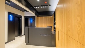 A reception area with a modern design, featuring a reception desk labeled "reception" and a wooden panel wall. - R34 Boutique Hotel (Sofia)