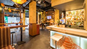 A bar area with stools, a counter with a frog design, and shelves with bottles. - R34 Boutique Hotel (Sofia)
