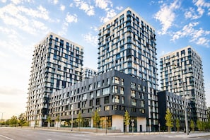 Un immeuble moderne à plusieurs étages, doté d’une structure d’angle remarquable, de grandes fenêtres et d’un toit plat.