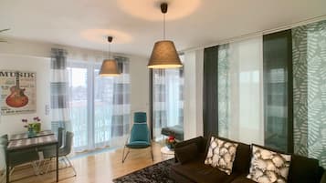 Apartamento com design assinado, 2 quartos, acessível, vista para a cidade | Área de estar | TV de tela plana 42 polegadas com canais digitais, TV LED