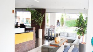 A modern lobby with a reception desk, seating area, and large windows. - Veredas Rio Quente (Rio Quente)