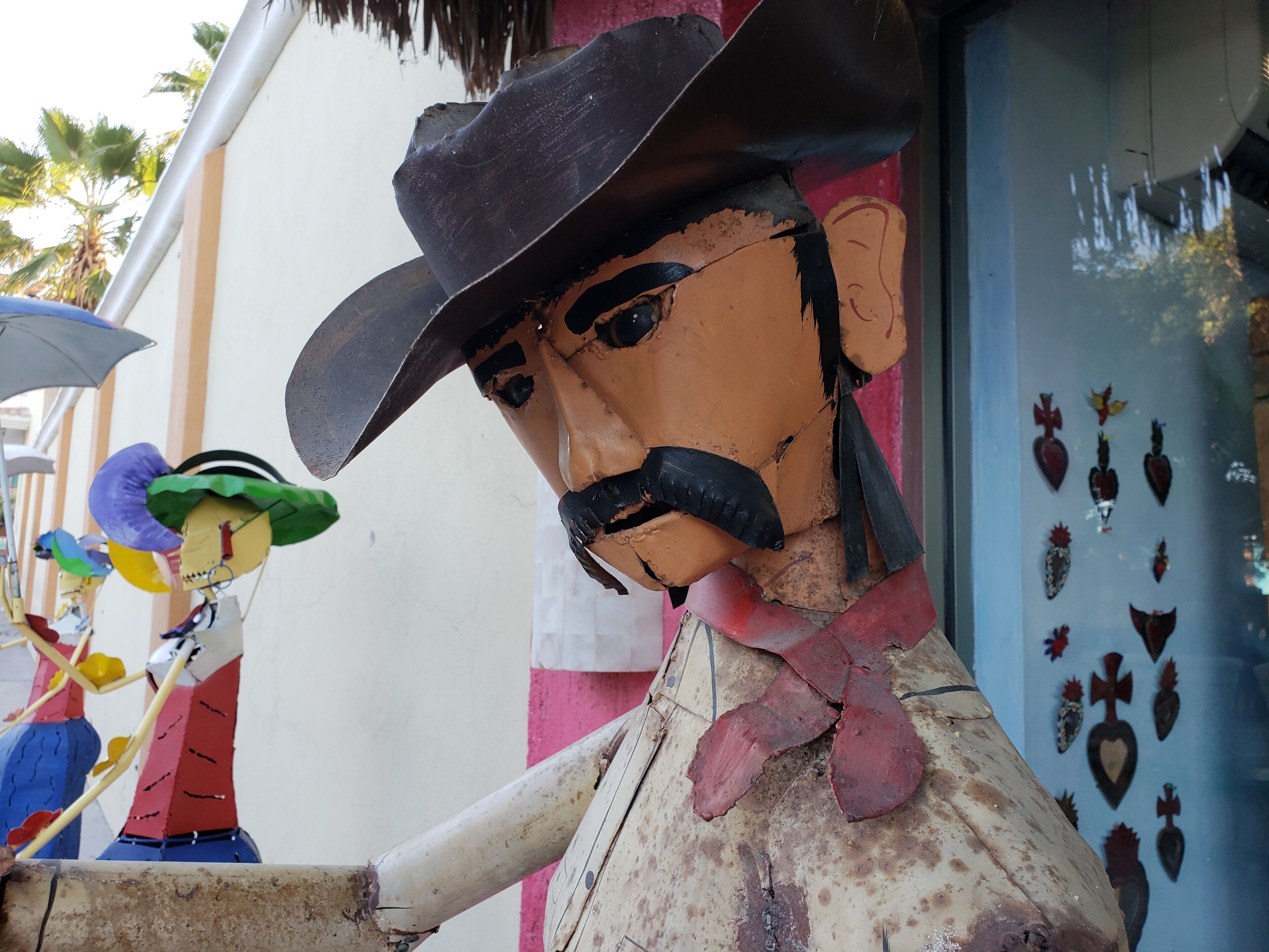 Une fresque représentant un homme portant un chapeau et une moustache, tenant une pipe et arborant un nœud papillon rouge.