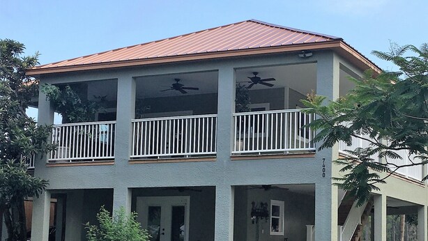 A two-story building with a red roof, balconies, and a covered porch area. - The Penthouse at Enchanted Acres Ranch (Cocoa)