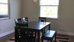 A dining area with a table and chairs, a patterned rug, and a chandelier. - The Penthouse at Enchanted Acres Ranch (Cocoa)