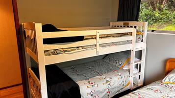 A bunk bed with a lower bunk and a top bunk, both with patterned bedding.