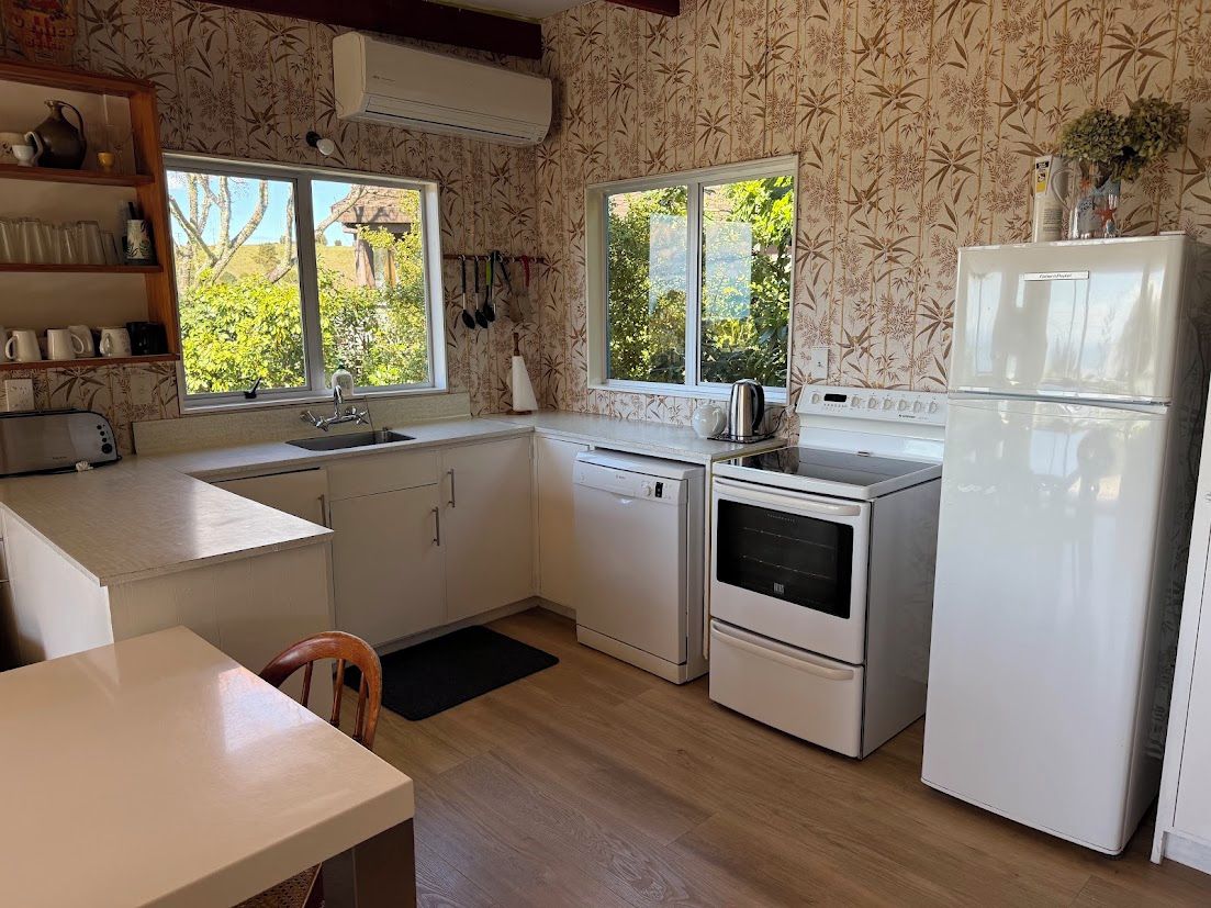 A kitchen with a window, a refrigerator, a stove, and a sink.