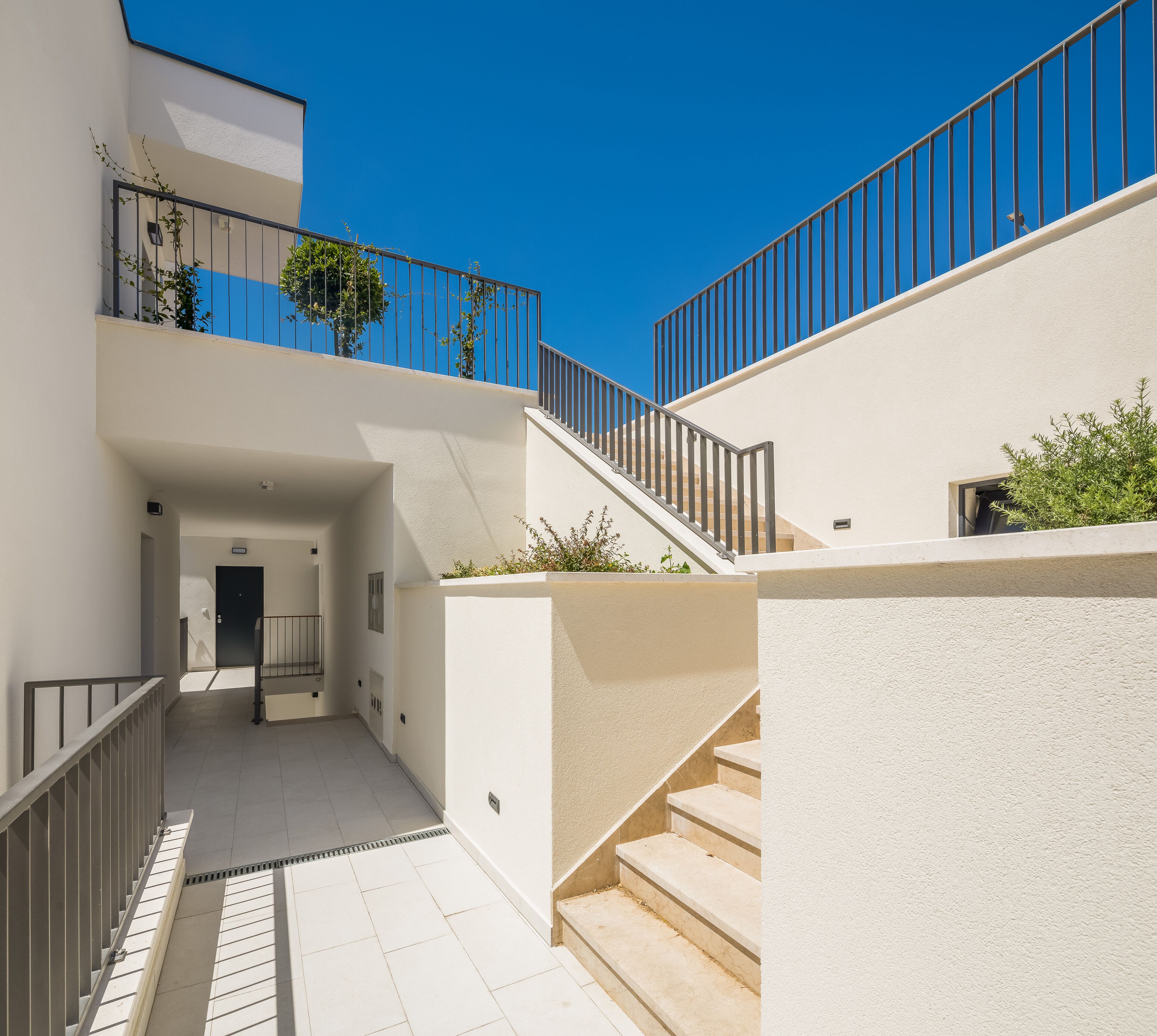 Un bâtiment moderne doté d’un escalier, d’un balcon et d’une porte.