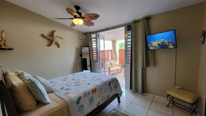 A bedroom with a bed, a ceiling fan, a TV, and a view of the outdoors. -  5 STAR BeachSide/Communal Pool/Private Spa/Terrace
NO CLEAN FEE Betwn Aug1-Nov1 (Ensenada)
