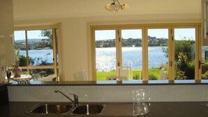 Cozinha com vista para um lago, uma pia e armários.