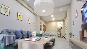 A modern living room with a sofa, a wooden coffee table, and a dining area with a table and chairs.