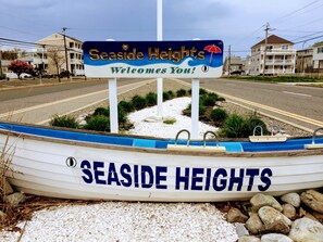 Señal de bienvenida a Seaside Heights, con un diseño al estilo de playa que incluye un bote y un paraguas.