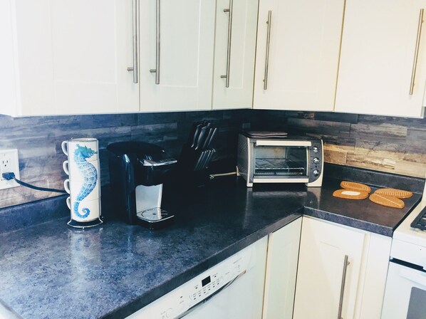 A kitchen with a toaster, a coffee maker, and a dishwasher.