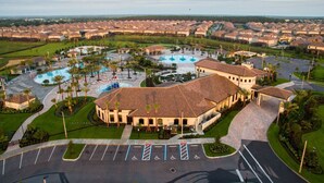 A residential area with a large building featuring a curved roof, a swimming pool, and a parking lot with handicapped accessibility. - Luxury Championsgate Villa (Davenport)