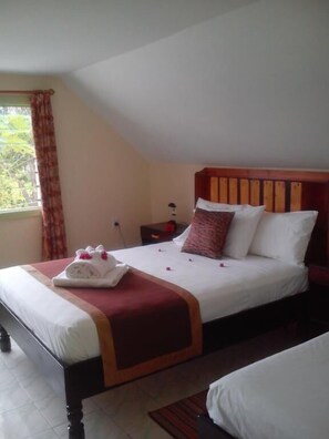 Ein Hotelzimmer mit Bett, Nachttisch und einem Vorhangfenster.