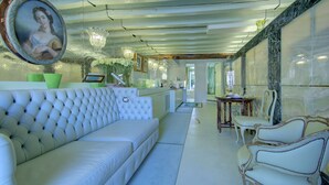 Een modern interieur met een witte bank, een eettafel met stoelen en een grote spiegel.