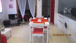 A compact living space with a dining area, kitchenette, and a TV. - STUDIO RENTAL DOMAINE DE LA BAUME (CENDRAS)