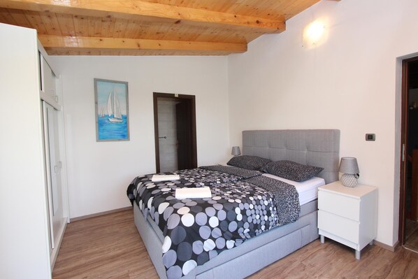 A bedroom with a bed, bedside table, and a door. - CUVI Holiday House with Garden (Rovinj)