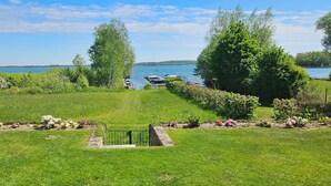 A grassy area with a pathway leading to a dock by a lake.