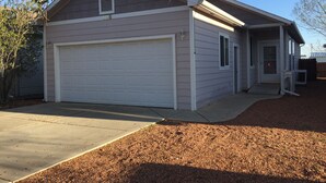 A single-story house with a garage, a small porch, and a driveway. - Central Cedaredge Cottage (Cedaredge)