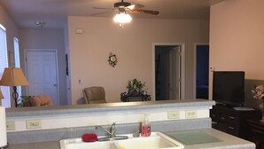 A kitchen with wooden cabinets, a white sink, and a ceiling fan. - Central Cedaredge Cottage (Cedaredge)