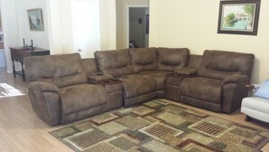 A sectional sofa in a living room with a patterned rug.