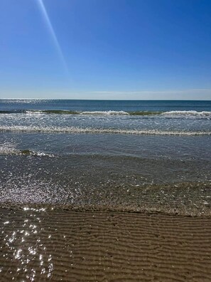 A beach with clear water and a sandy shore.