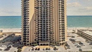 Un hotel moderno con numerosi piani, un cortile interno e vista sulla spiaggia.