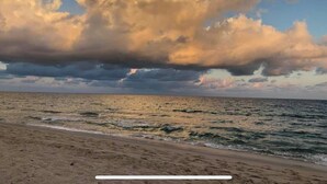 A beach with a wide sandy shore and a large body of water.