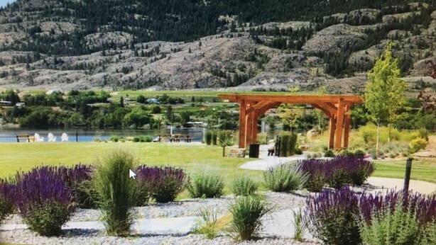 Un jardín con un pórtico de madera, un estanque y montañas al fondo.