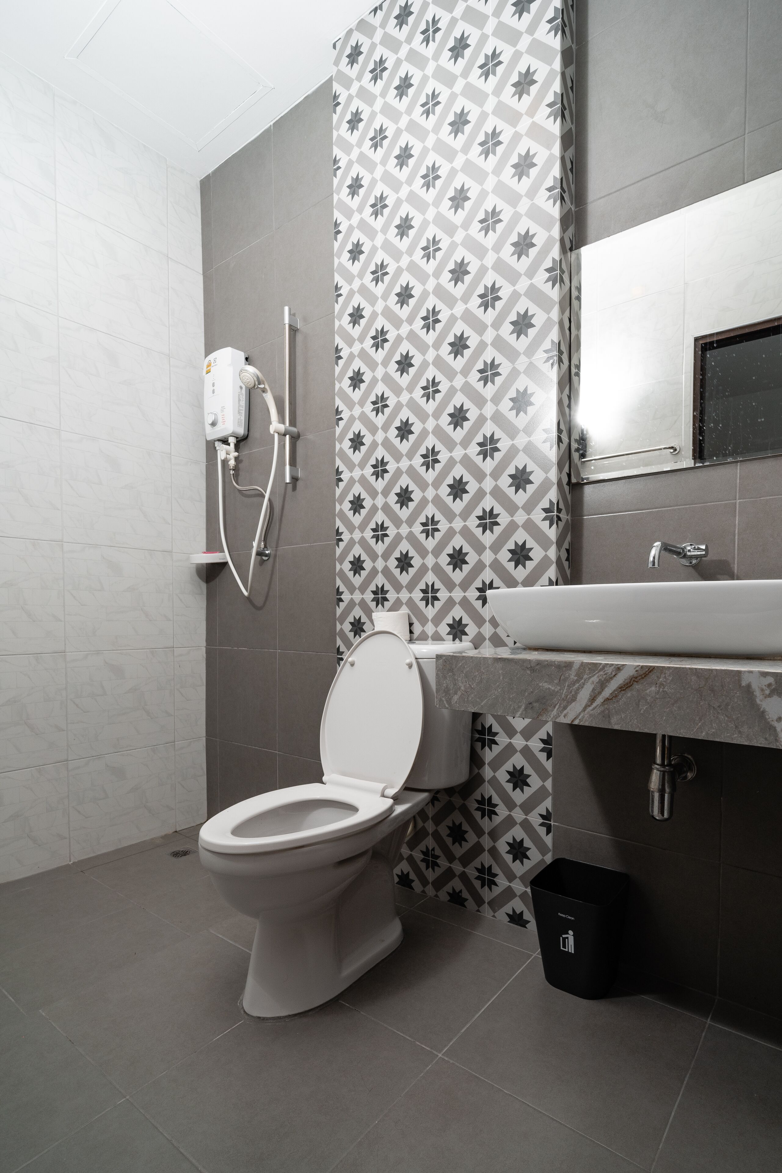 A modern bathroom with a toilet, shower, and sink.