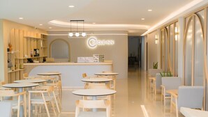 A modern Circle Inn reception area with a central desk, multiple seating arrangements, and a clean, polished floor. - Circle Inn Ao Nam Mao (Krabi)