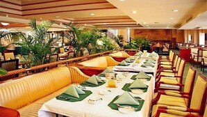 A spacious dining area with long tables set for multiple guests, surrounded by comfortable seating and lush greenery. - Dolton International Hotel Changsha (Changsha)