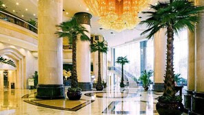 A spacious lobby with high ceilings, large chandeliers, and palm trees. - Dolton International Hotel Changsha (Changsha)